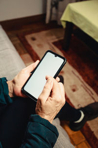 Cropped hand of man using mobile phone outdoors