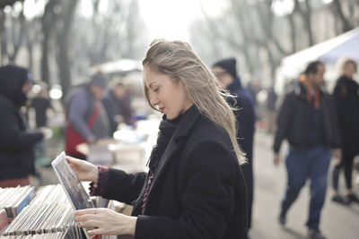 Beautiful woman choose a vinyl in a vintage market