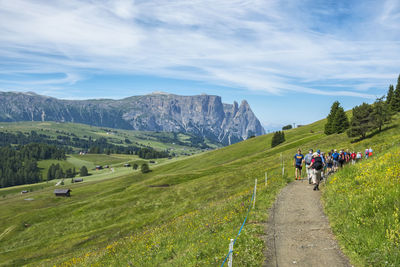 Hiking group in a beautiful alp valley with flowering meadows