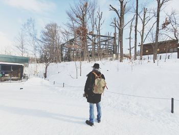 Full length rear view of person walking on snow