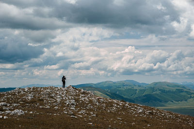 Woman standing on mountain against sky