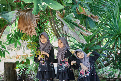 Cute asian muslim girls wearing hijab fashion with green tree in rural scene