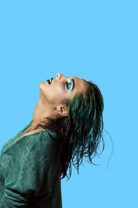 Portrait of woman against blue background