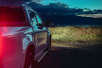 Reflection of car on road against blue sky