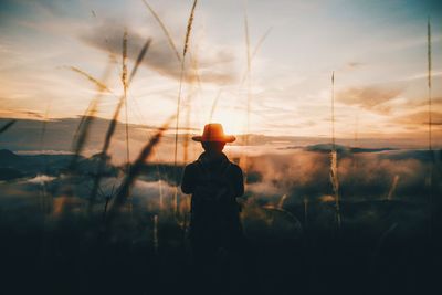 Silhouette man standing against sky during sunset