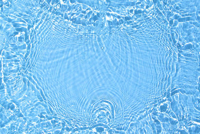 Transparent blue colored clear calm water surface texture