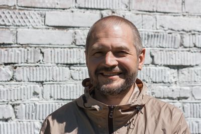 Portrait of smiling man against wall