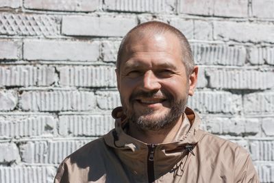 Portrait of smiling man against wall