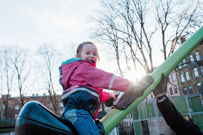 Young girl playing in a park in sweden at sunset with her dad