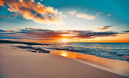 Scenic view of beach against sky during sunset