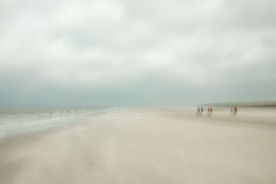 People on beach against sky