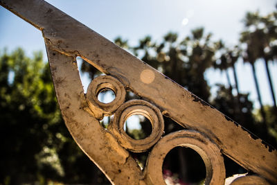 Low angle view of old rusty wheel against sky