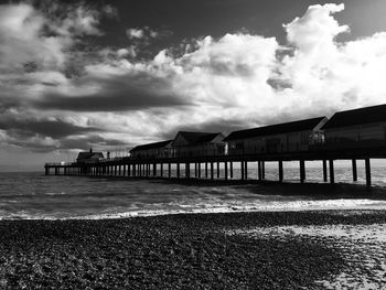 Pier on beach against sky