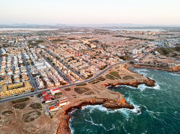 Aerial view of buildings by sea in city