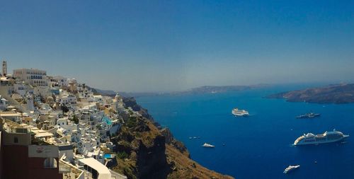 High angle view of cityscape by sea against clear sky