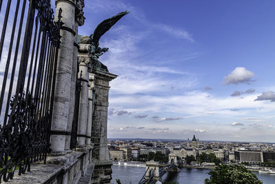 Statue in city against sky