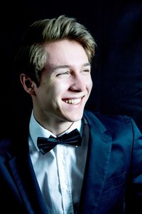 Smiling young man wearing bow tie and suit