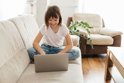 A schoolgirl girl studies at home on a laptop and makes calls with a teacher.