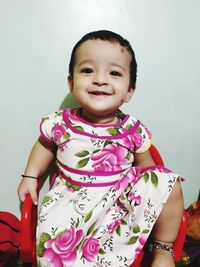 Portrait of smiling girl sitting at home