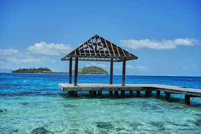 Lifeguard hut on beach against blue sky
