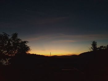 Silhouette trees against sky at night