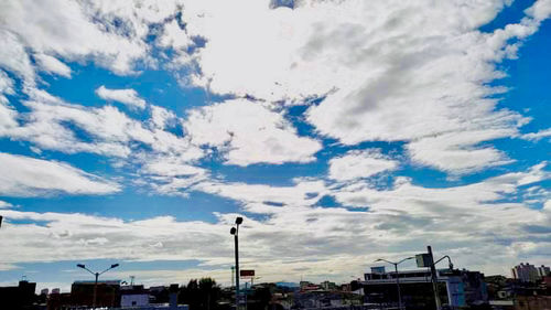 Buildings in city against cloudy sky