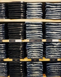 Full frame shot of jeans arranged on shelves for sale at store