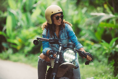 Smiling woman looking away while sitting on motorcycle