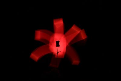 Close-up of illuminated red light against black background