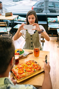 Portrait of smiling young woman having food at restaurant