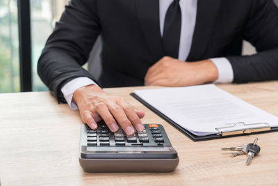 Midsection of man using laptop on table