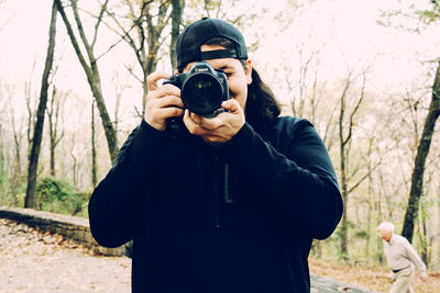 Young man photographing with camera