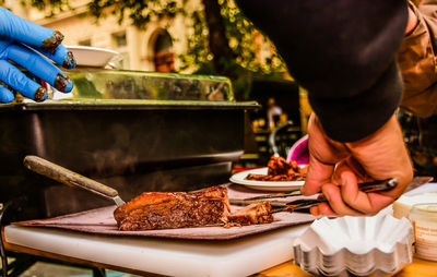 Cropped hand serving food in plate