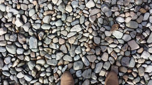 Low section of person standing on pebbles