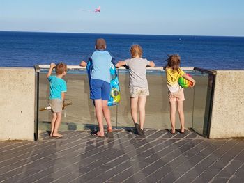 People on beach by sea against sky