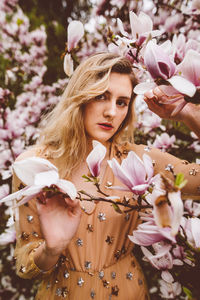 Young woman amidst pink flowers during springtime