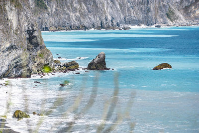 Scenic view of sea against rock formation