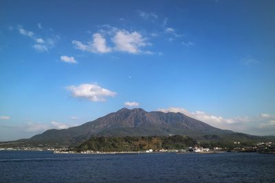 Scenic view of sea and mountains against blue sky