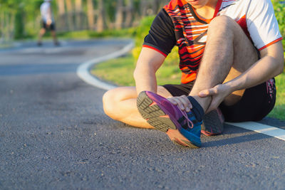 Low section of man skateboarding on road