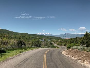 Empty road along countryside landscape