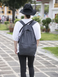 Rear view of man standing on footpath