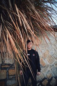 Portrait of young man standing against wall