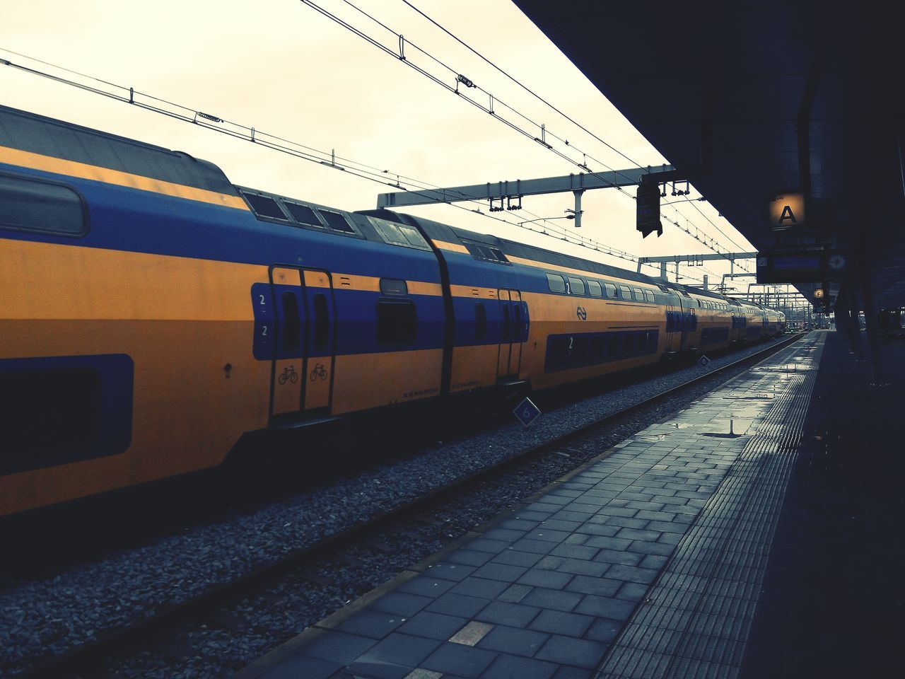 railroad track, transportation, rail transportation, public transportation, built structure, railroad station, railroad station platform, building exterior, architecture, train - vehicle, mode of transport, sky, power line, cable, outdoors, no people, day, electricity pylon, clear sky, connection