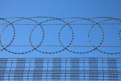 Low angle view of barbed wire against sky