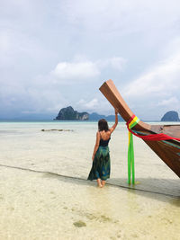 Full length of woman on beach against sky