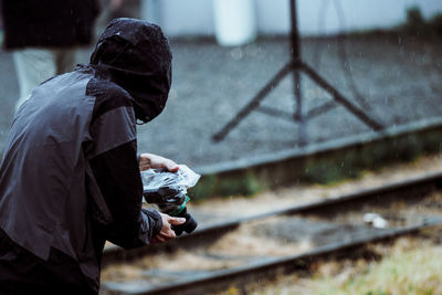 Side view of man standing on railroad track