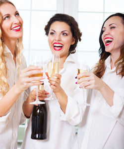 Smiling young woman drinking glasses