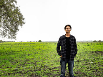 Portrait of young man standing on field