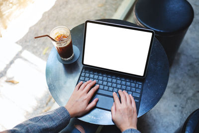 A woman using and typing on tablet keyboard with blank white desktop screen as computer pc