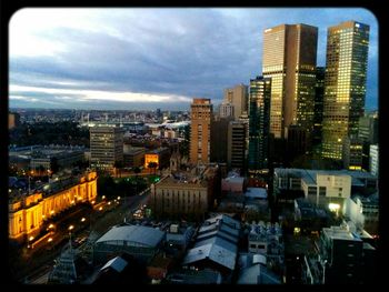 View of cityscape against cloudy sky